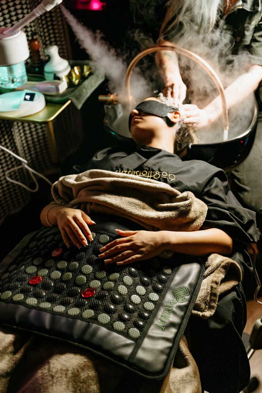 Person receiving a relaxing steam facial treatment in a spa setting.
